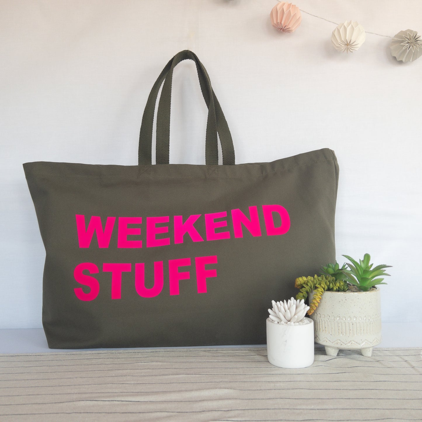 Personalised forest green tote bag shown carried on shoulder strap