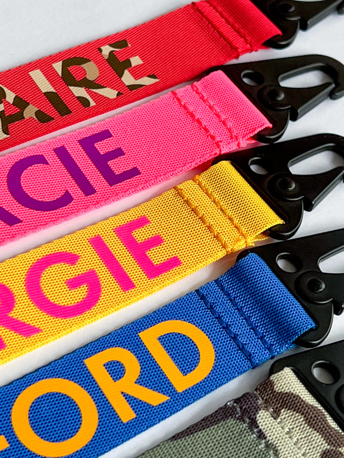 Personalised wristlet key ring attached to bag handle